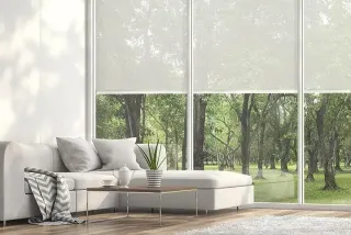 Tryba_Belgique_Dcouvrez_les_produits.webp Un salon lumineux avec un canapé moderne et une grande baie vitrée donnant sur un paysage boisé verdoyant.